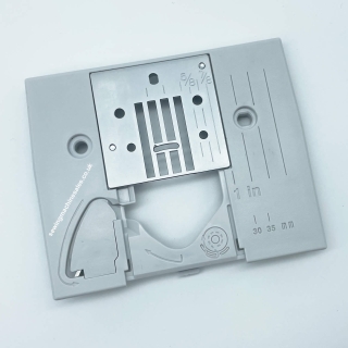 Needle plate with cutter and metal feed cover plate